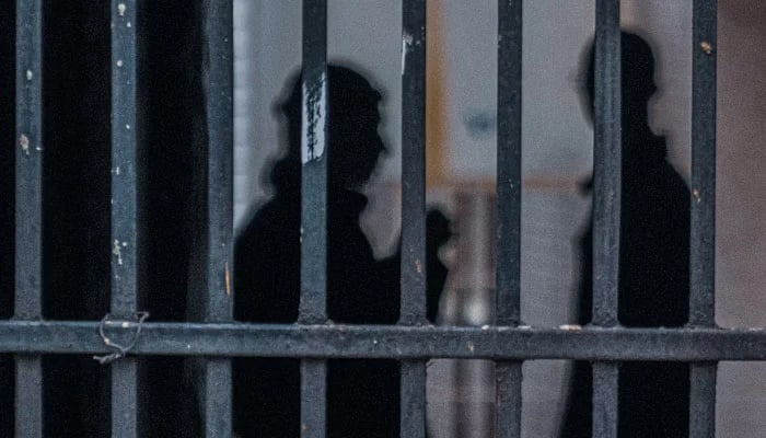 Representational image of inmates behind jail bars. — Unsplash