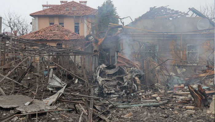 A destroyed car in front of damaged houses following a missile attack in Odesa.— Rte/File