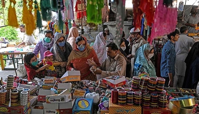 Customers shop at a local market in Pakistan. — AFP/File