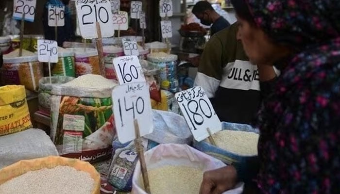 A woman views prices of rice being sold at a shop in Pakistan. — AFP/File