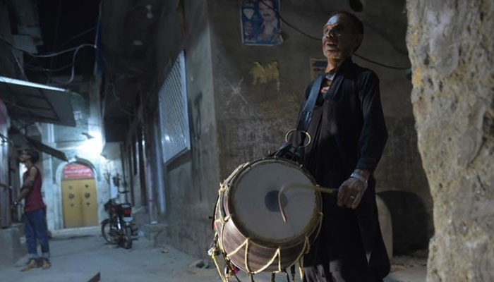 This image shows a man beating his drum as he makes calls at doors to wake up and eat your sehri morning meal before their fasting during Ramadan. — AFP/File
