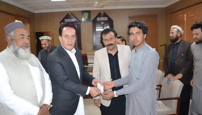 Former MNA Shahabuddin Khan along with  Deputy Commissioner Muhammad Anwarul Haq distributed the cheques to families affected by the recent rains on March 15, 2024. — Facebook/Deputy Commissioner Bajaur