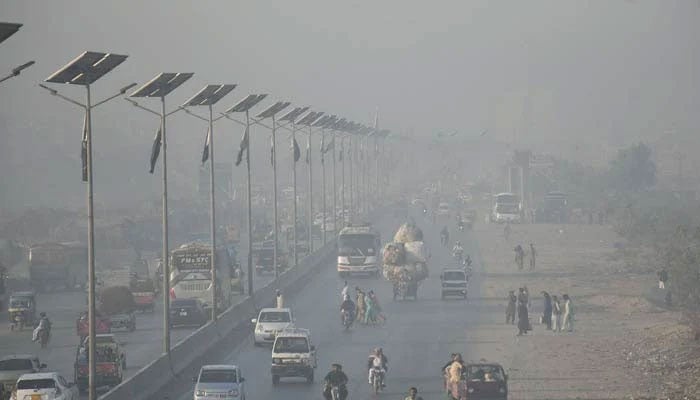 Motorists on their way during heavy smog in the morning hours in Lahore. — Online/File