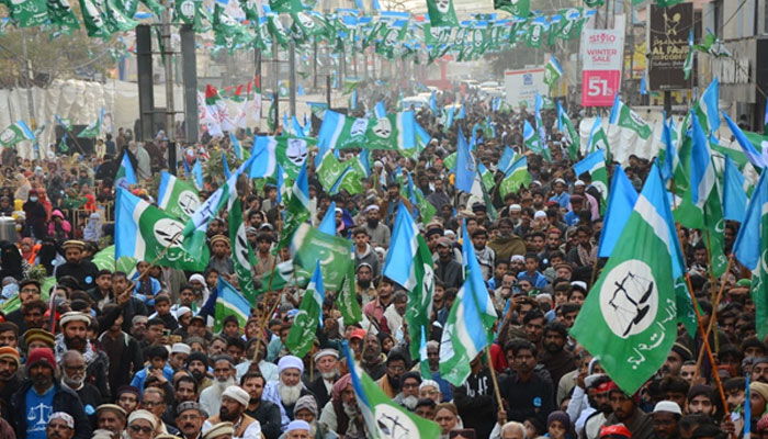 Supporters of the Jamaat-e-Islami hold flags in a rally. — Online/File