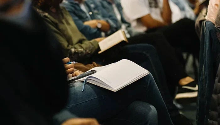A representational image shows participants in a seminar with a diary. — Unsplash/File