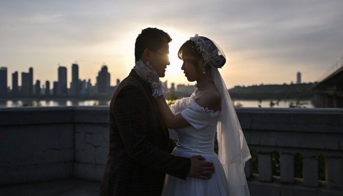 This photo shows a newly married Chinese couple during a photoshoot. — AFP/File