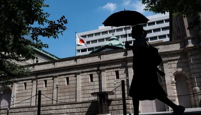 A pedestrian walks past the Bank of Japan (BoJ) building in central Tokyo on July 28, 2023. — AFP/File