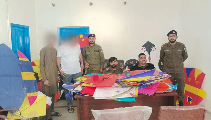 This image shows police officials pictured with arrested kite sellers in a police station. — Facebook/Rawalpindi Police/File