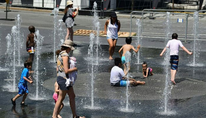 People play in water fountains at the Place des Arts in Montreal, during a deadly heatwave. — AFP/File