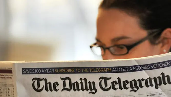In this image, a woman reads The Daily Telegraph newspaper. — AFP/File