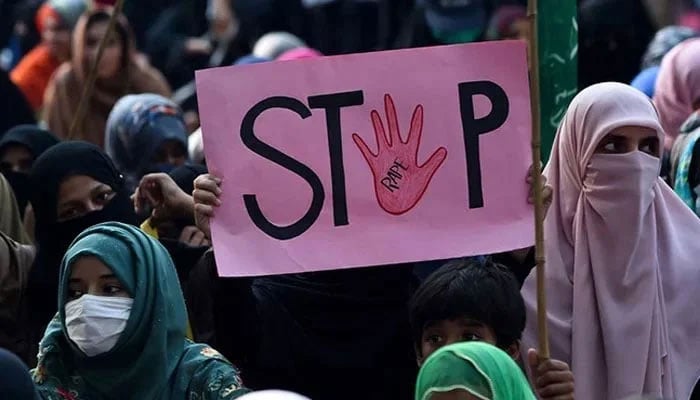 A person holds a placard reading Stop rape during a protest against the alleged gang rape of a woman. — AFP/File