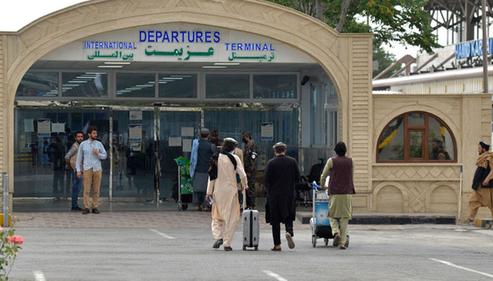 Passengers with their belongings walk towards the entrance gate of the airport in Kabul. — AFP/File