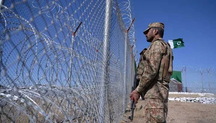 A Pakistan Army soldier stands vigilant along a border fencing. — AFP/Files