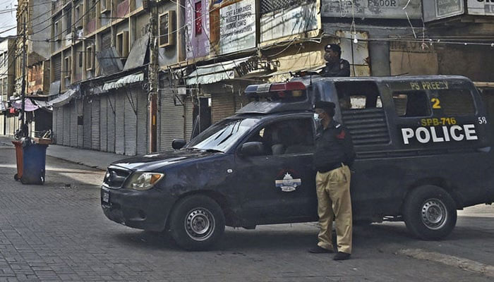 Police stand guard at a commercial market area in Karachi. — AFP/File
