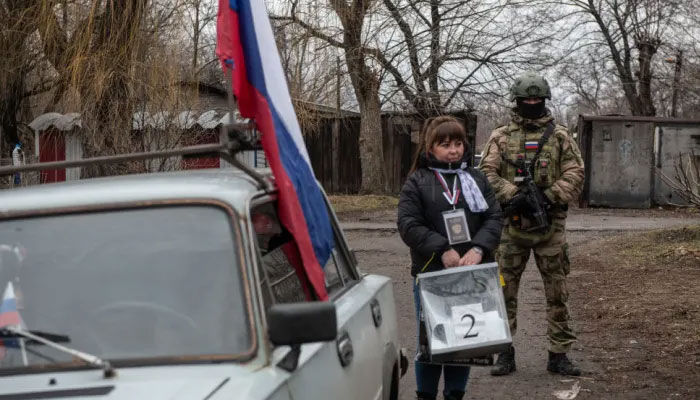 A member of a local election commission, accompanied by a serviceman, visits voters during early voting in Russia’s presidential election in Donetsk, Russian-controlled Ukraine, amid the Russia-Ukraine conflict on March 14, 2024.—AFP