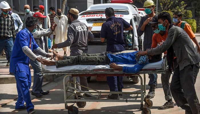 Paramedics personnel shift a patient on a stretcher into the hospital in Karachi, Pakistan. — AFP/File