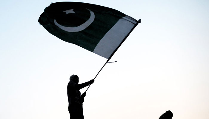A representational image showing a person waiving the flag of Pakistan. — AFP/File