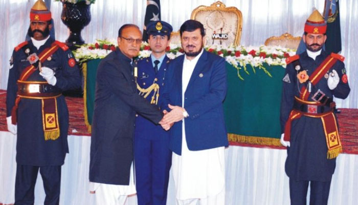 Amjad Aziz Malik shakes hands with KP Governor Ghulam Ali after receiving Tamgha-e-Imtiaz. — APP/File
