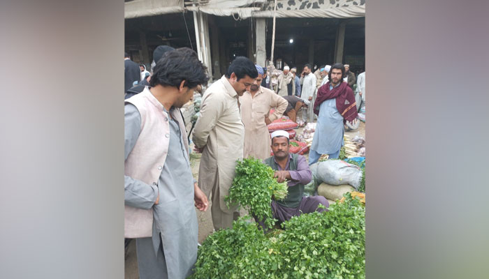 Deputy Commissioner Mardan Muhammad Fayyaz Khan Sherpao speaks to the vendor during his visits to fruit and vegetable market on March 24, 2024. — Facebook/Deputy Commissioner Mardan