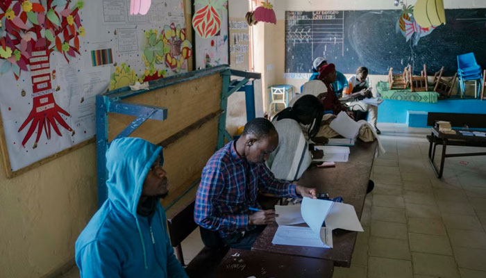 Commission Electorale Nationale Autonome (CENA) officials check the voters rolls at a polling station in a school in HLM Grand Medine on the outskirts of Dakar, Senegal on March 24, 2024. — AFP
