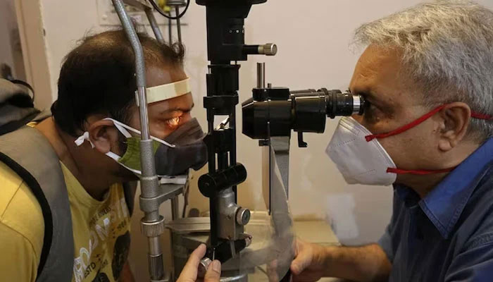A doctor carries out a patients eye examination. — AFP/File