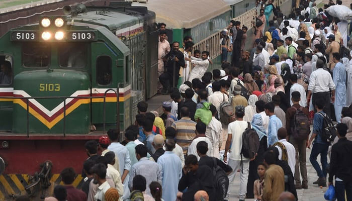 People board a train at a railway station. — AFP/File
