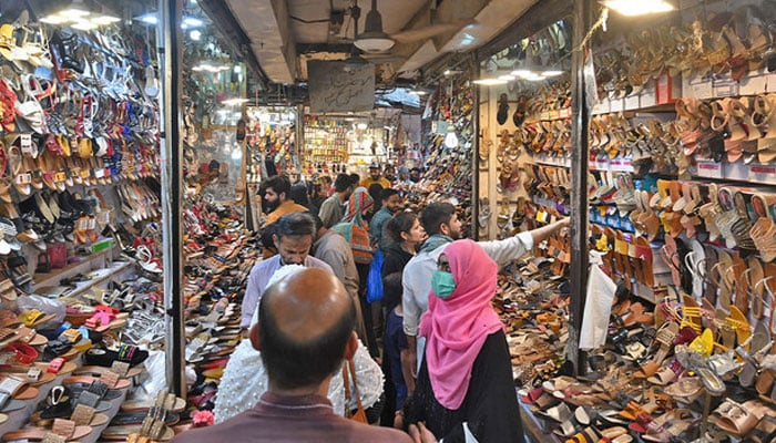 People shop at a market in Lahore. — AFP/File