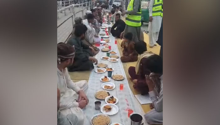 In this still, Muslims break their fast at Iftar during the Holy month of Ramadan arranged by Saylani Welfare Trust at University Road, Peshawar on March 26, 2024. — Facebook/Saylani Welfare International Trust
