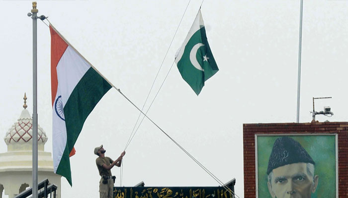 A soldier raises Pakistani flag at a border crossing between Pakistan and India. — AFP/File