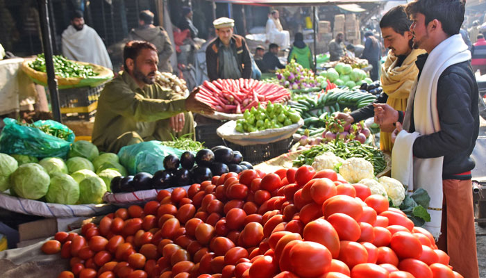 People are buying vegetables from a vendor at the Fruit and Vegetables Market in Islamabad. — Online/File