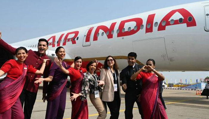 Crew members pose next to Indias first Airbus A350 of Air India airline on January 18, 2024. — AFP