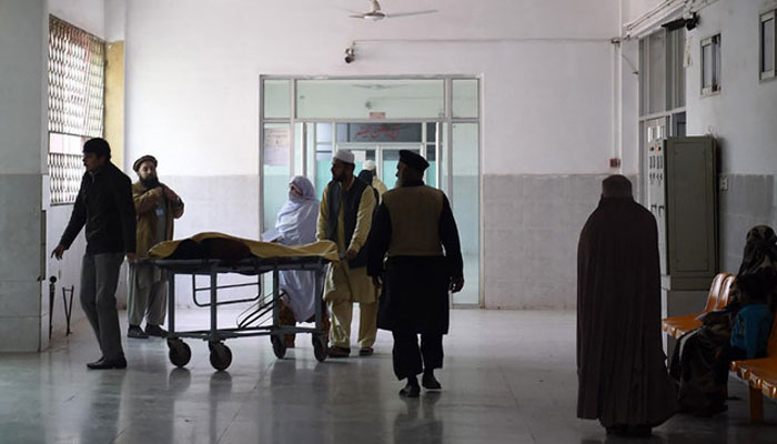 Pakistani relatives tend to a man treated at a hospital in Pakistan. — AFP/File