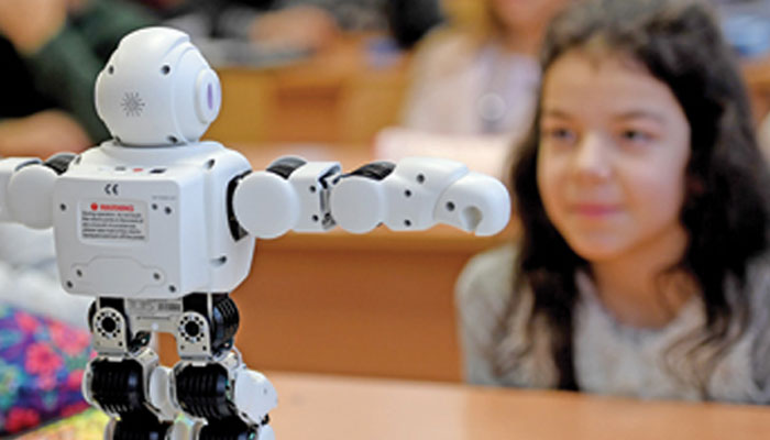This representational image shows children interacting with robots. — AFP/File