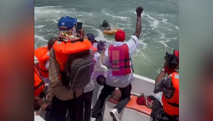 Supporters of Akinrodoye Samuel cheer, while he swims to complete his ambitious endeavor to swim the 11.8 km stretch of the Third Mainland Bridge, advocating for the theme Swim Against Suicide And Depression in Lagos, Nigeria on March 30, 2024. — X/@Zikoko_Mag