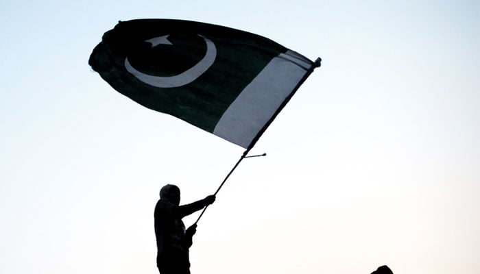 A representational image of a person waving the flag of Pakistan. — AFP/File