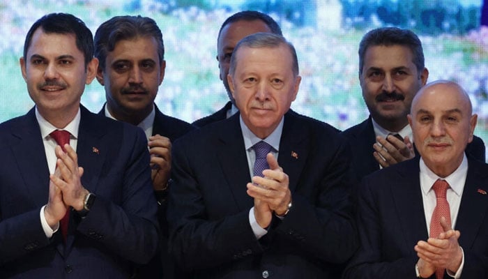 Turkish President Recep Tayyip Erdogan (C) poses with Istanbul Metropolitan Mayor candidate Murat Kurum (L) and Ankara metropolitan munucipality Mayor candidate Turgut Altinook (R) during the presentation of the Justice and Development Partys (AK Party) election manifesto at the AK Party Congress Centre in Ankara on January 30, 2024. — AFP