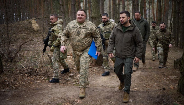This photo from the Ukrainian Presidential press service shows Zelensky walking with Ukrainian servicemen in the Sumy region on March 27, 2024. — AFP