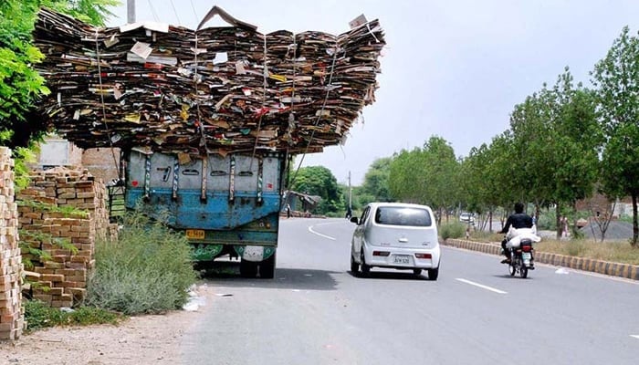 In this image overloaded truck is parked alongside the road. — APP/File