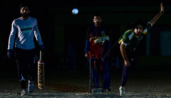 A player delivers a ball during a nighttime cricket tournament during the month of Ramadan. — AFP/File
