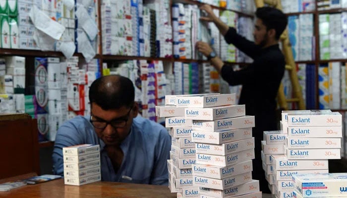 Pharmacists arrange medicines at a pharmacy shop in Peshawar on September 1, 2021. — AFP