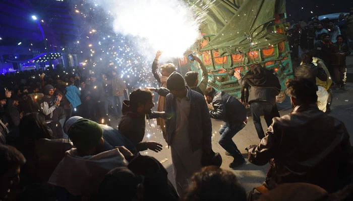 Pakistani youth enjoy the firework display during the New Year celebrations. — AFP/File