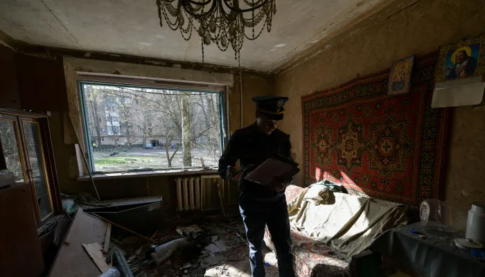 A Russian emergencies ministry member inspects damage to a flat in an apartment block hit by suspected Ukrainian shelling in the Russian-controlled area of Donetsk. — AFP/File