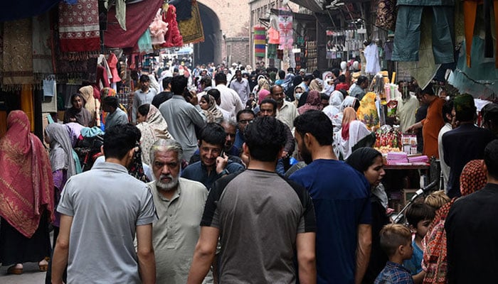 In this picture taken on April 16, 2023, people throng a market area during shopping in Lahore. — AFP