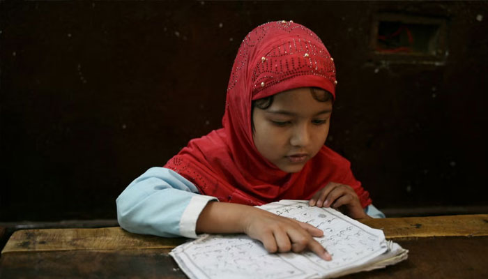A student recites the Holy Quran in a classroom during the Islamic holy month of Ramadan at the Madrasatur-Rashaad religious school in Hyderabad. — AFP