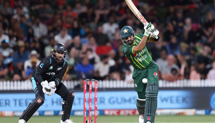 Pakistan´s Babar Azam bats while being watched by New Zealand wicketkeeper Devon Conway (L) during the second Twenty20 international cricket match between New Zealand and Pakistan at Seddon Park in Hamilton on January 14, 2024. — AFP