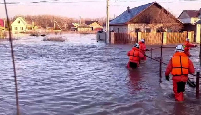 Rescuers make their way on a flooded residential area in the city of Orsk, Russia on April 6, 2024. — AFP