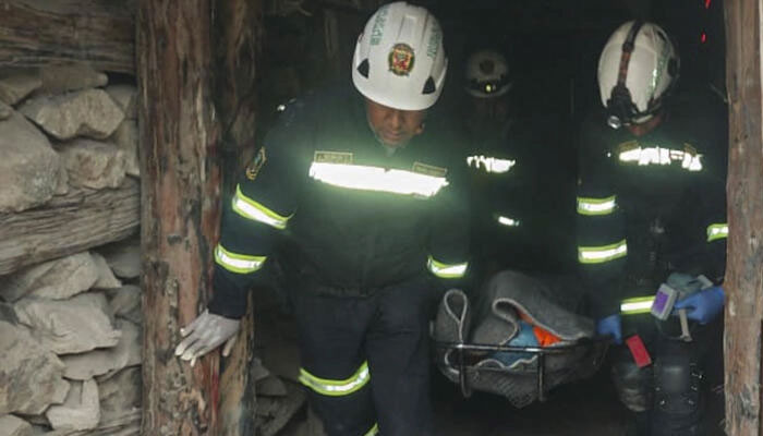 A handout picture released by the Peruvian National Police shows officers carrying the remains of one of the victims of a fire at La Esperanza mine in the Yanaquihua district of Arequipa, southern Peru on May 7, 2023. — AFP