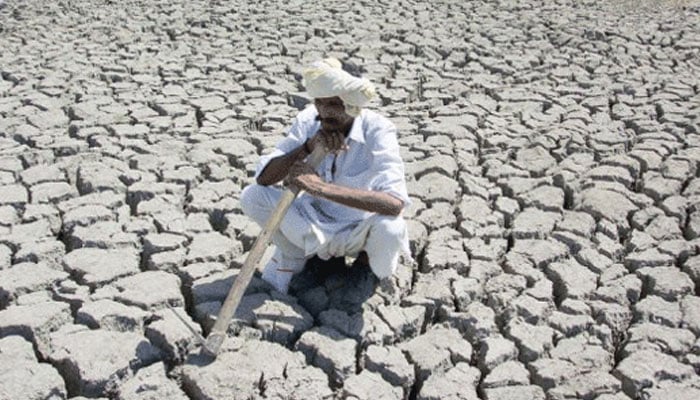 A representational image showing a farmer sitting on a dried out farm land. — AFP/File