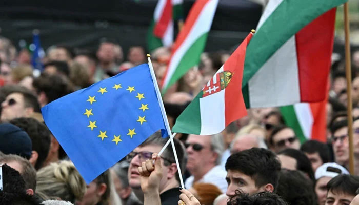 Protesters display the Hungarian and the European flag in a rally in downtown Budapest to denounce the Hungarian government and corruption on April 06, 2024. — AFP