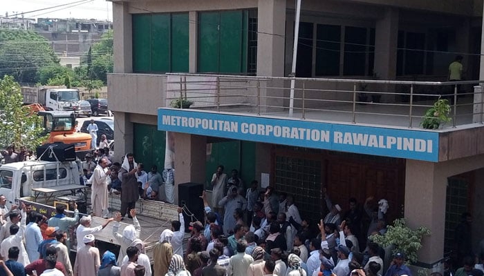 In this image, People gather outside the Metropolitan Corporation Rawalpindi (MCR) building. — Facebook/Metropolitan Corporation Rawalpindi/File